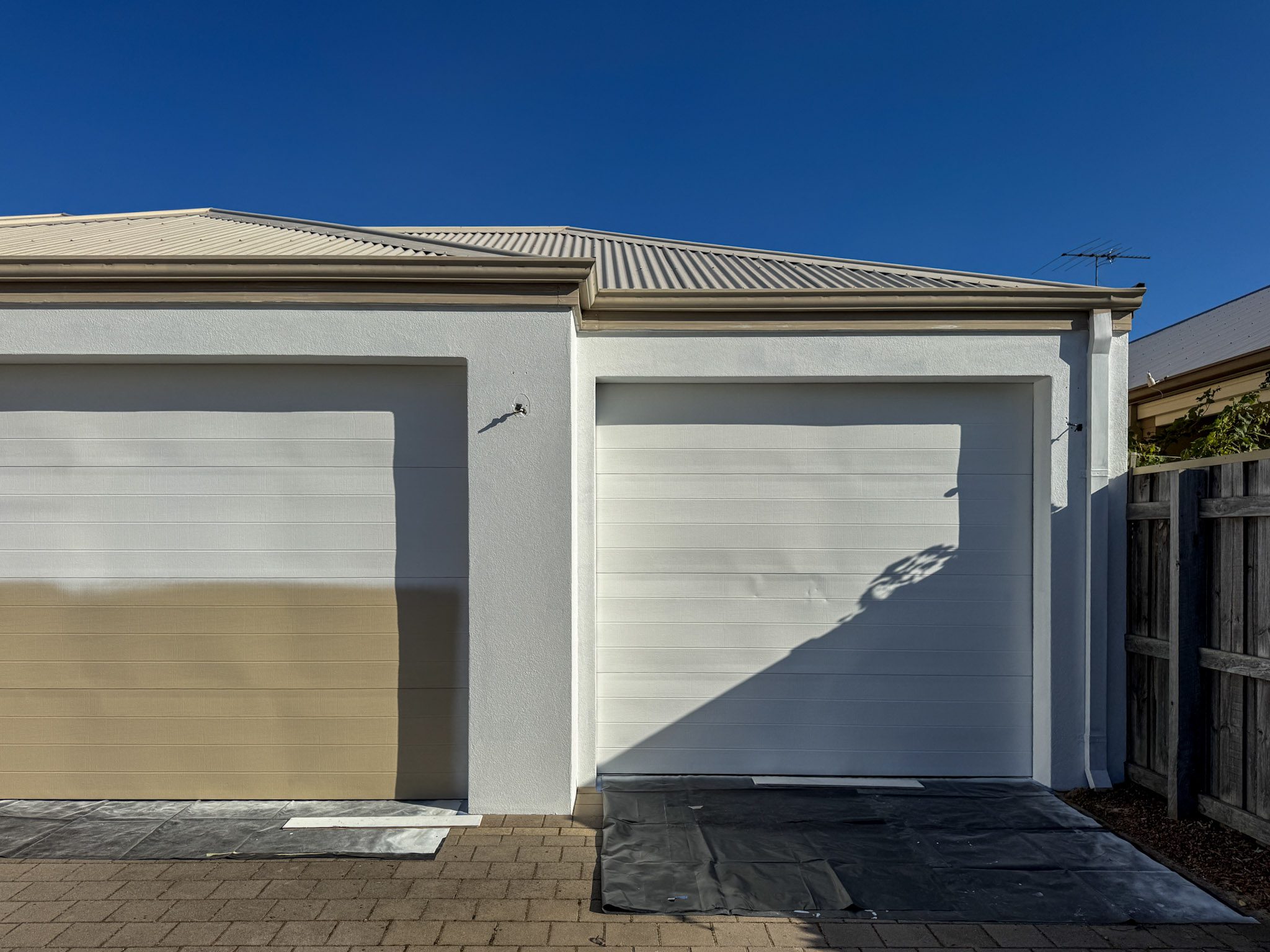 Mandurah home with garage door and exterior walls painted in Dulux Snowy Mountains Half for a modern, unified facade